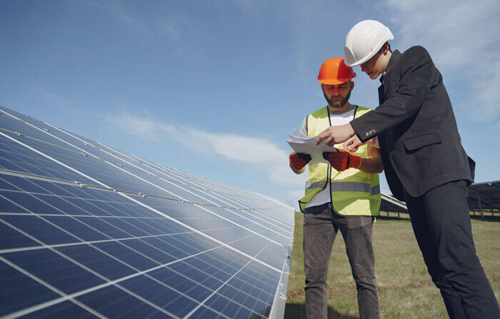 men in front of solar panels