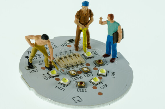 plastic toy figures on top of round electronic circuit