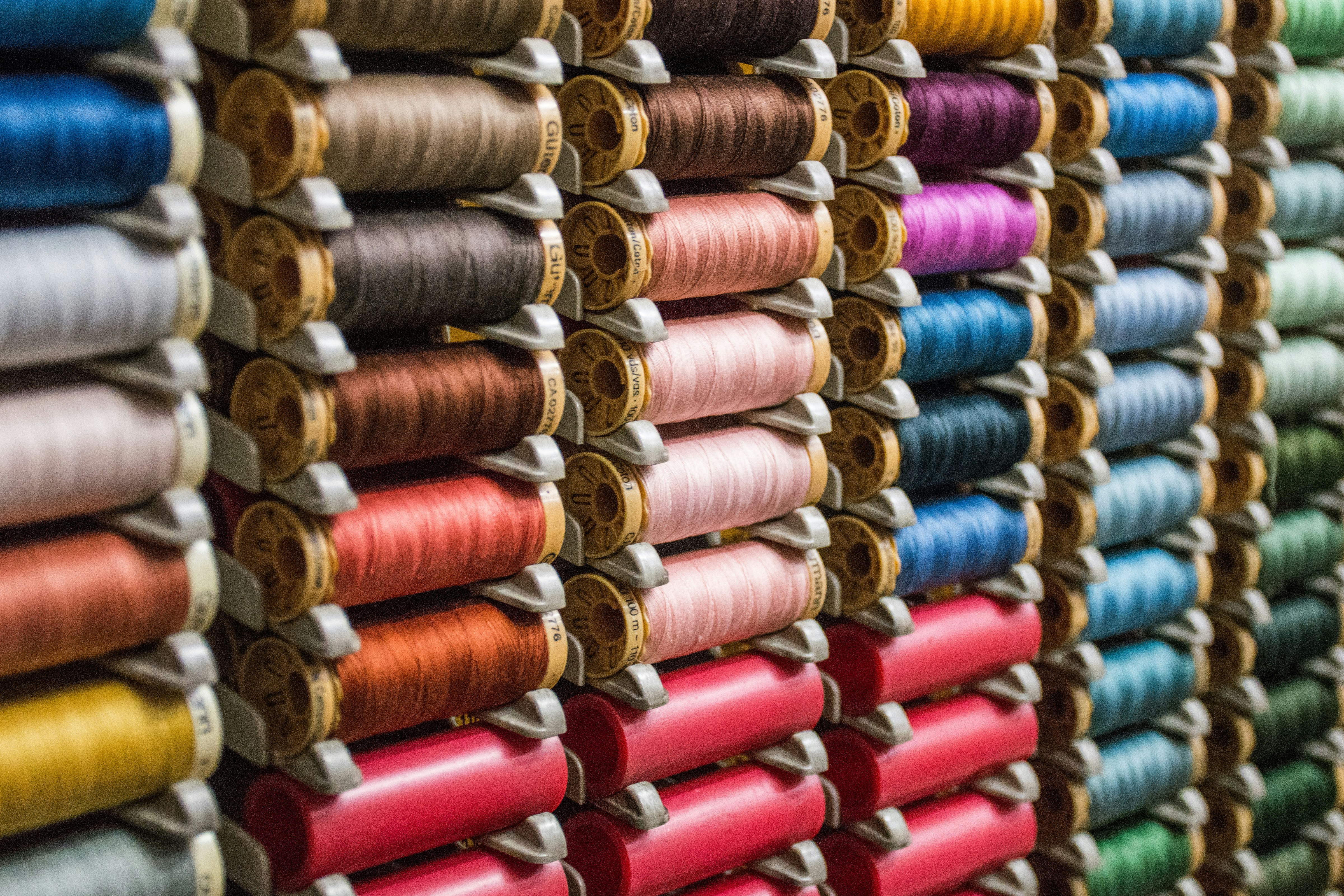 many spools of different color thread on a rack