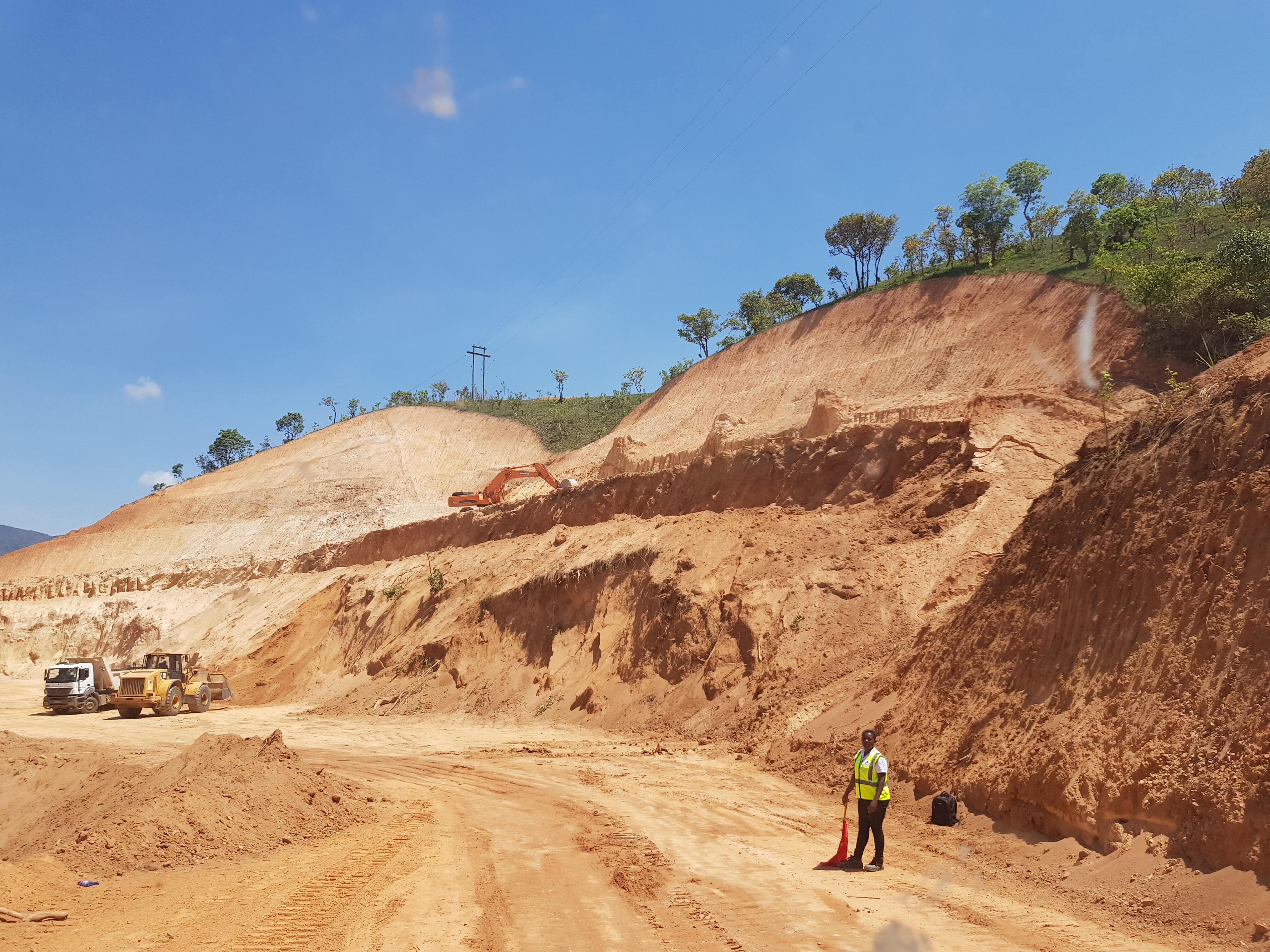 photo of male worker standing in mining pit