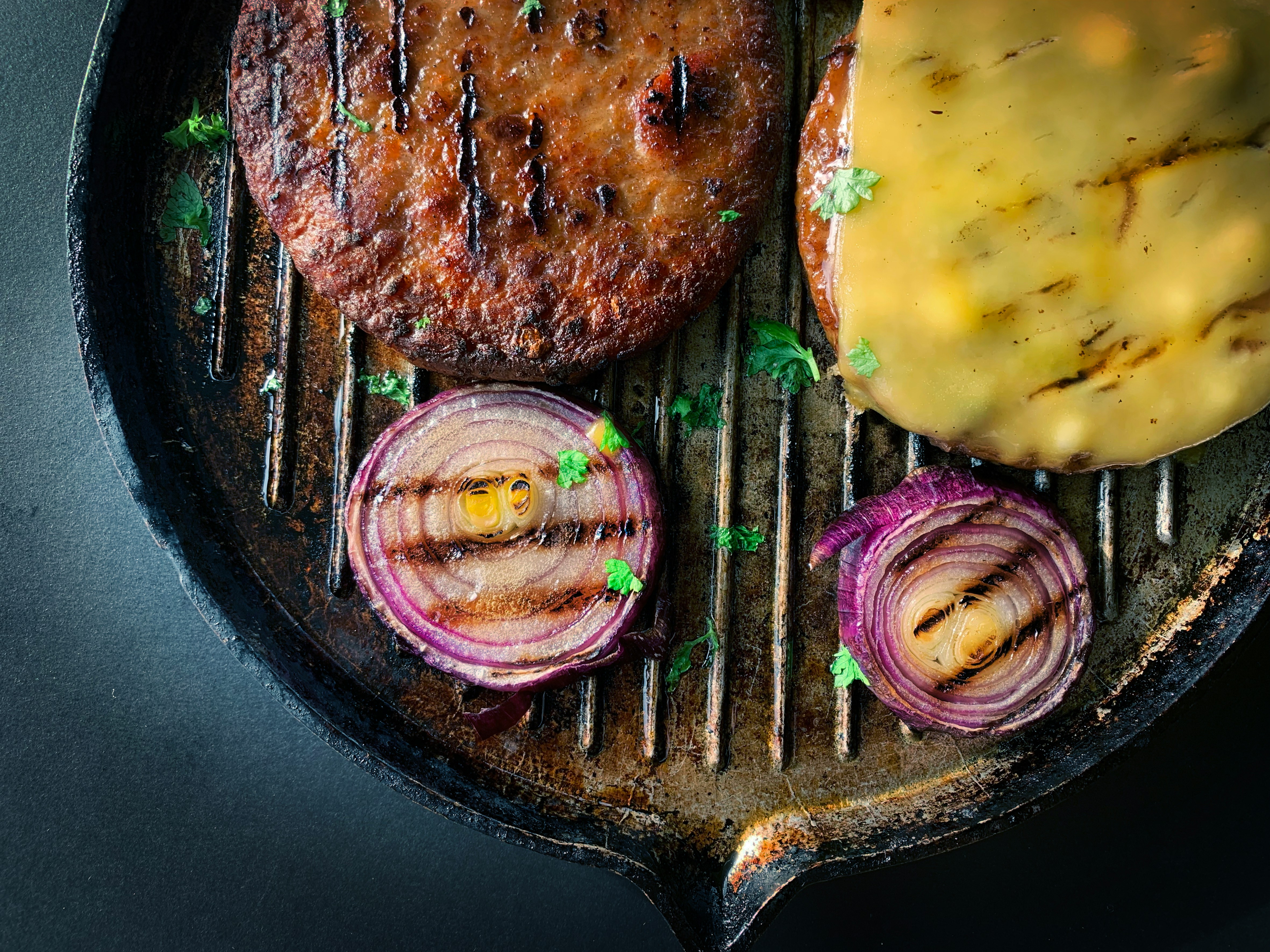 veggie burgers and onions in a cast iron skillet